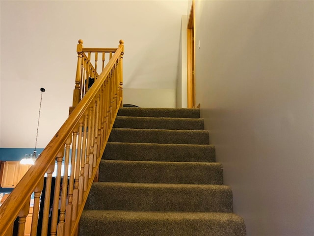 stairs with an inviting chandelier