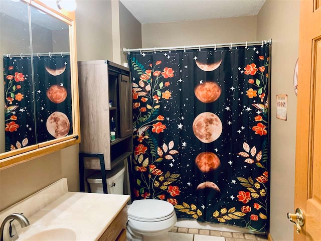 bathroom featuring curtained shower, vanity, and toilet