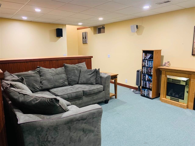 living room with carpet flooring and a paneled ceiling