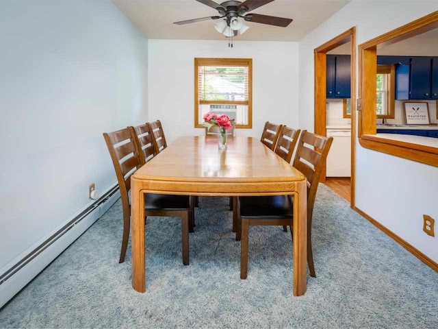 dining room with ceiling fan, cooling unit, light colored carpet, and a baseboard heating unit