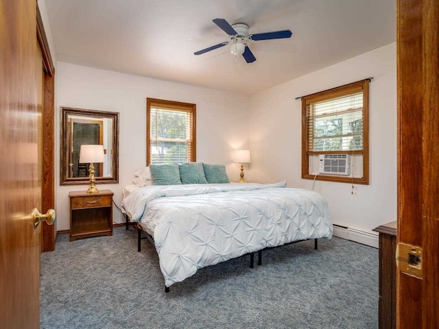 bedroom featuring dark carpet, baseboard heating, multiple windows, and ceiling fan