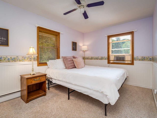 carpeted bedroom with ceiling fan and baseboard heating