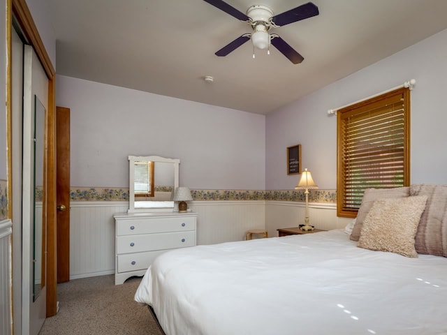 carpeted bedroom featuring ceiling fan and a closet