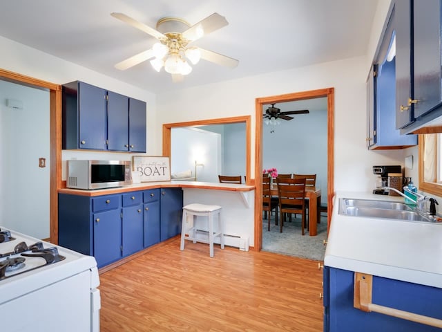 kitchen featuring sink, light wood-type flooring, a baseboard heating unit, and blue cabinets