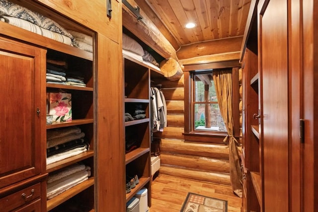 mudroom with rustic walls, light hardwood / wood-style flooring, and wooden ceiling