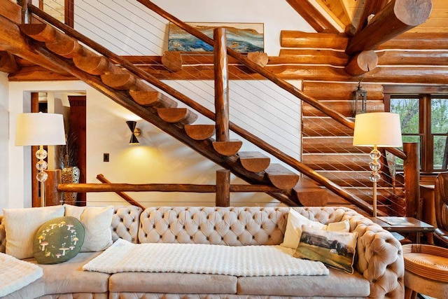 interior space with beam ceiling, rustic walls, and high vaulted ceiling