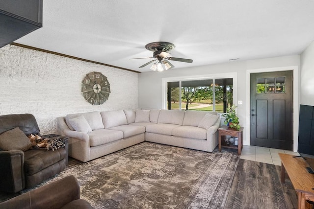 living room featuring hardwood / wood-style flooring, ceiling fan, and crown molding