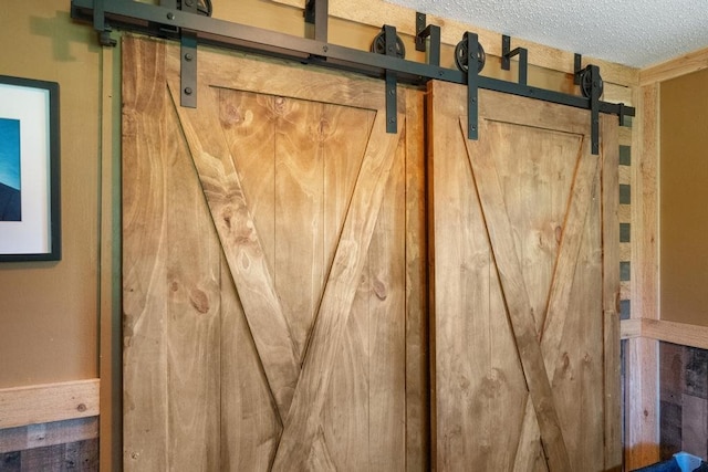 interior details with a barn door and a textured ceiling