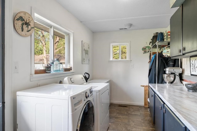 clothes washing area featuring cabinets, independent washer and dryer, and a wealth of natural light