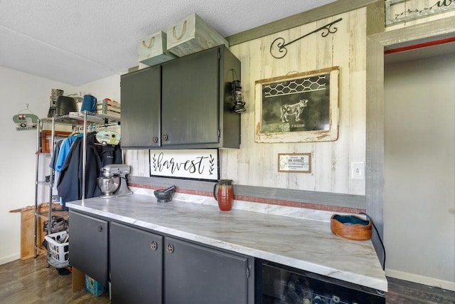 kitchen featuring a textured ceiling, dark hardwood / wood-style floors, and wine cooler