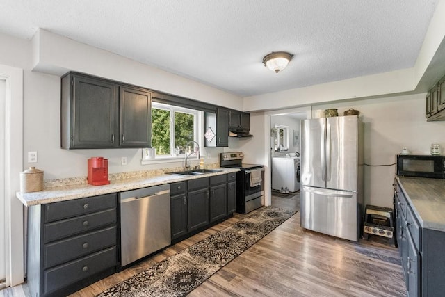 kitchen with a textured ceiling, dark hardwood / wood-style floors, sink, and appliances with stainless steel finishes