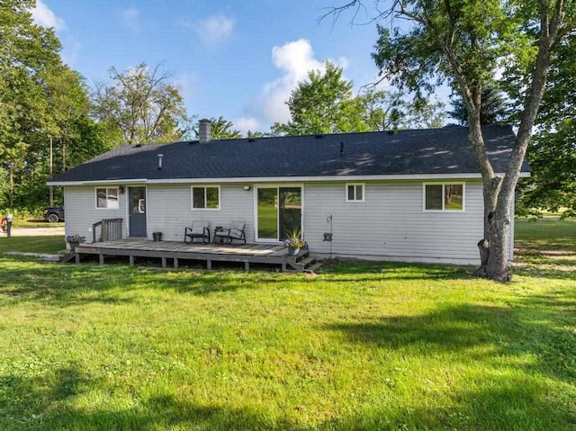 back of house featuring a lawn and a deck