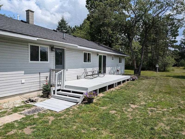 back of house with a lawn and a wooden deck