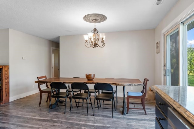 dining room featuring an inviting chandelier and dark wood-type flooring