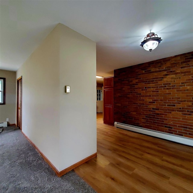 hall with hardwood / wood-style floors and a baseboard heating unit