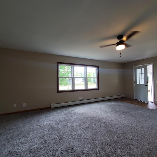 carpeted spare room featuring ceiling fan and a baseboard heating unit