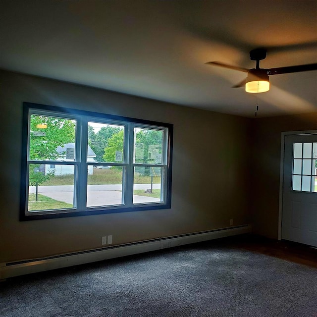 carpeted spare room featuring plenty of natural light, ceiling fan, and baseboard heating