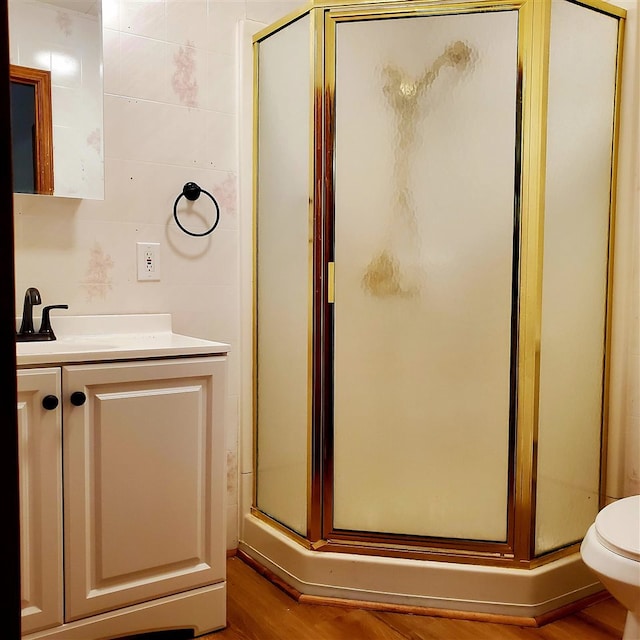 bathroom with hardwood / wood-style floors, vanity, toilet, and an enclosed shower