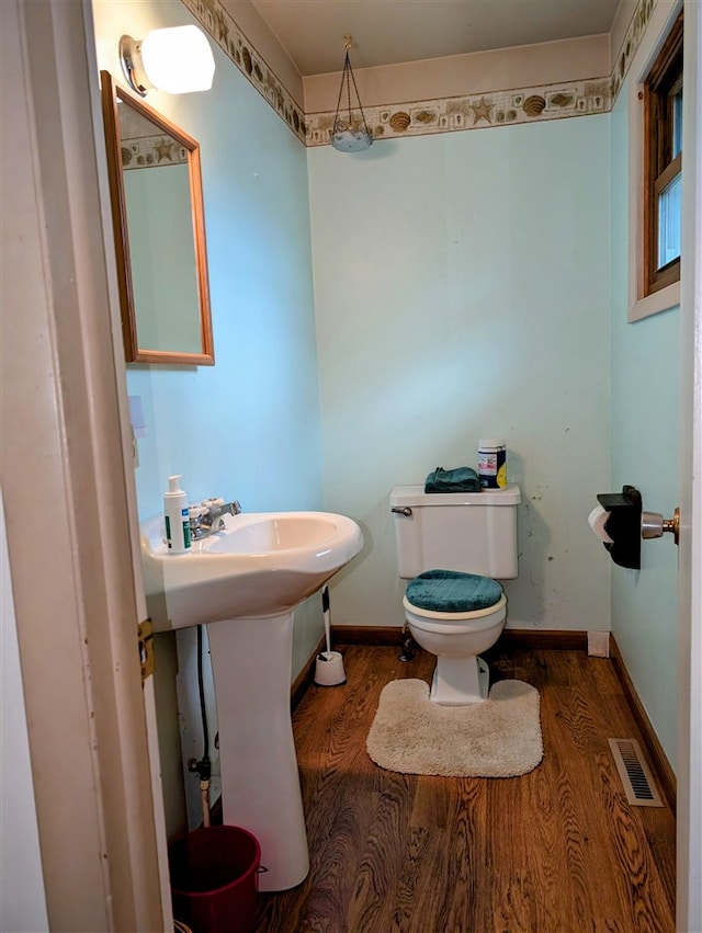 bathroom featuring wood-type flooring and toilet