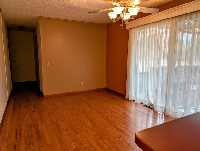 empty room with ceiling fan, ornamental molding, a textured ceiling, and hardwood / wood-style flooring