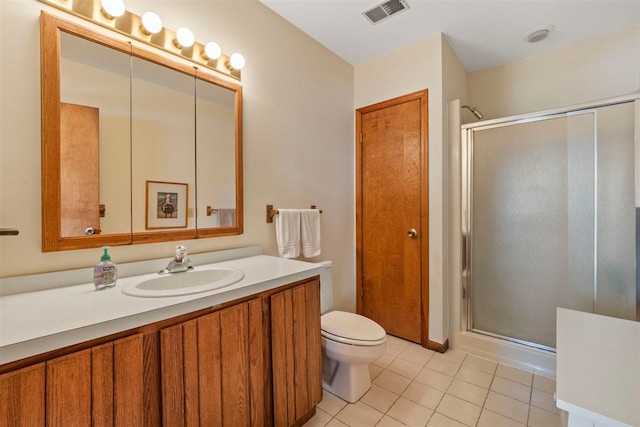 bathroom featuring tile patterned flooring, vanity, a shower with shower door, and toilet