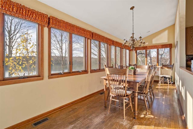 dining room featuring vaulted ceiling, dark wood-type flooring, and a notable chandelier