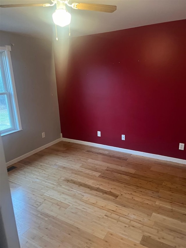 empty room with ceiling fan and light hardwood / wood-style floors