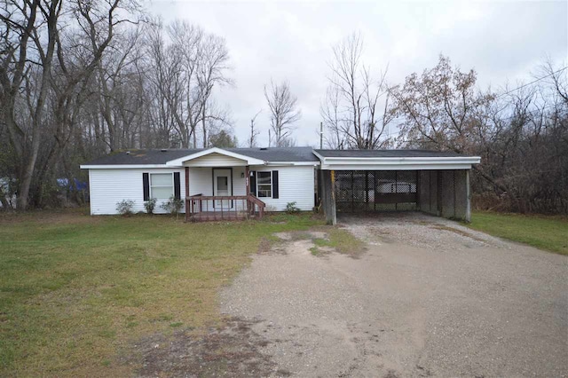 ranch-style home featuring a carport, covered porch, and a front lawn