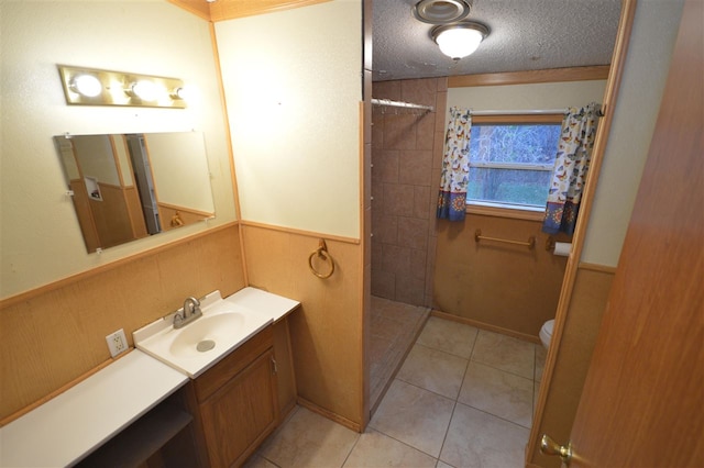 bathroom featuring vanity, tile patterned floors, toilet, a textured ceiling, and walk in shower