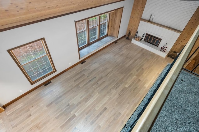 unfurnished living room featuring wooden ceiling, a healthy amount of sunlight, and light hardwood / wood-style floors