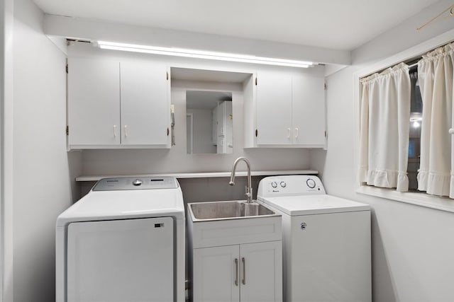 laundry area featuring cabinets, washing machine and dryer, and sink