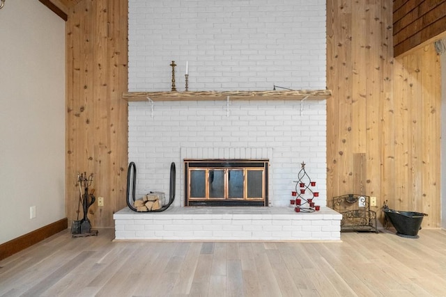 room details featuring a fireplace, hardwood / wood-style floors, and wooden walls