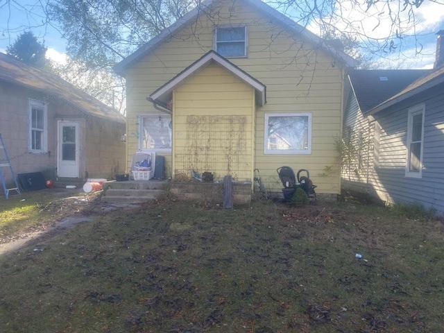 rear view of property featuring a lawn