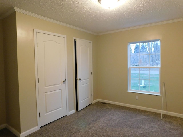 unfurnished bedroom with carpet floors, a textured ceiling, and ornamental molding