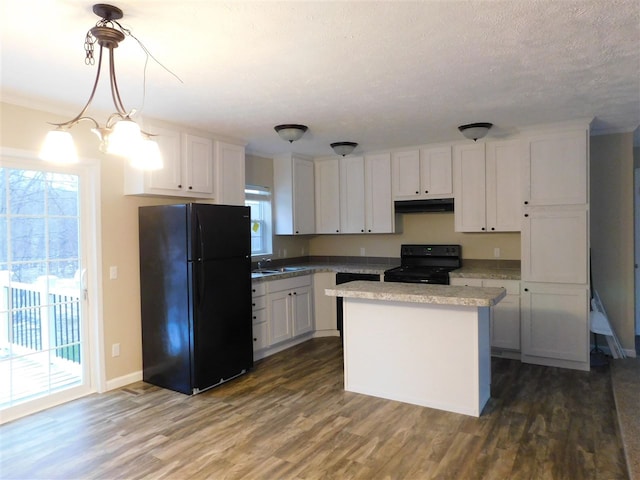 kitchen featuring dark wood-type flooring, a wealth of natural light, hanging light fixtures, and black appliances