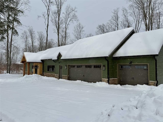 view of snow covered exterior featuring a garage