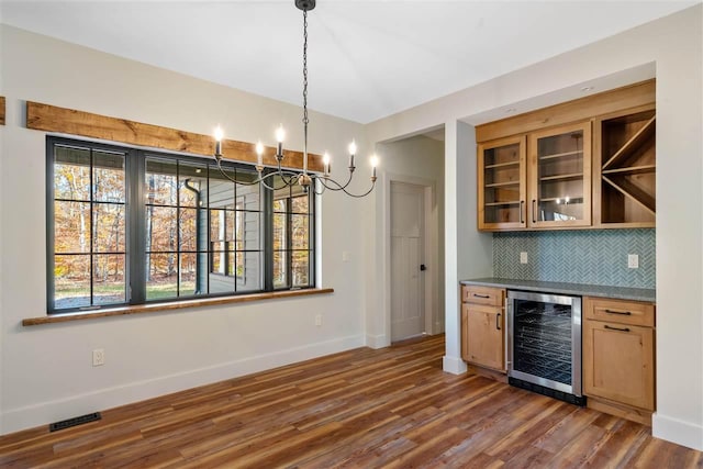 kitchen with hanging light fixtures, dark hardwood / wood-style floors, plenty of natural light, and beverage cooler