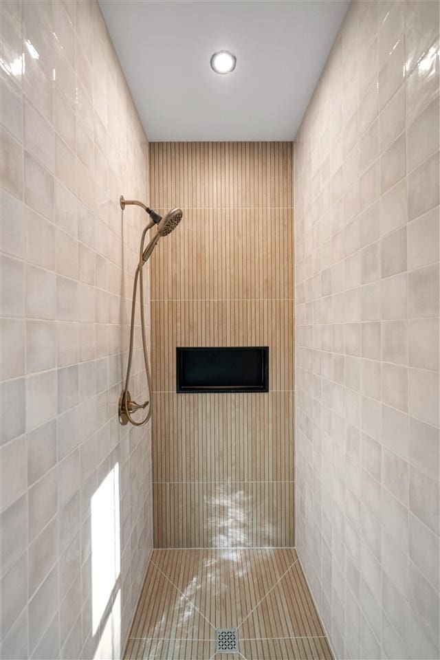 bathroom with tile walls and walk in shower