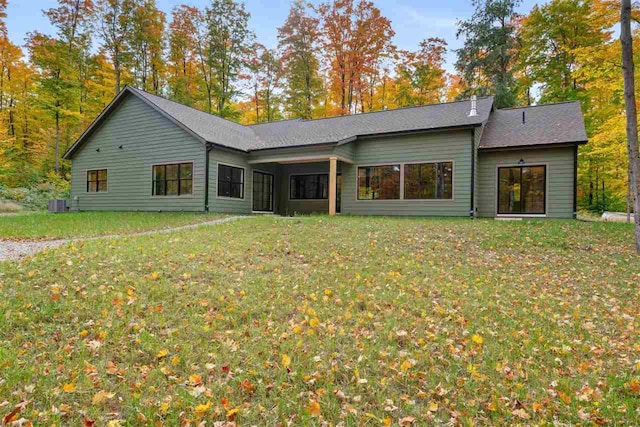 rear view of house with a lawn and central air condition unit