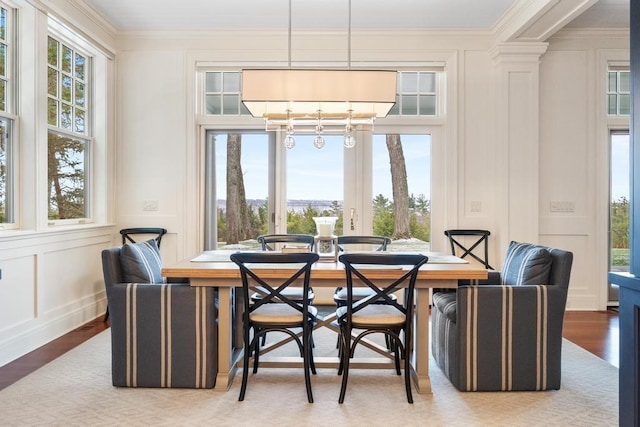 dining space with a notable chandelier, ornamental molding, and light hardwood / wood-style flooring