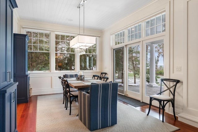 dining space featuring a chandelier, dark hardwood / wood-style floors, and crown molding