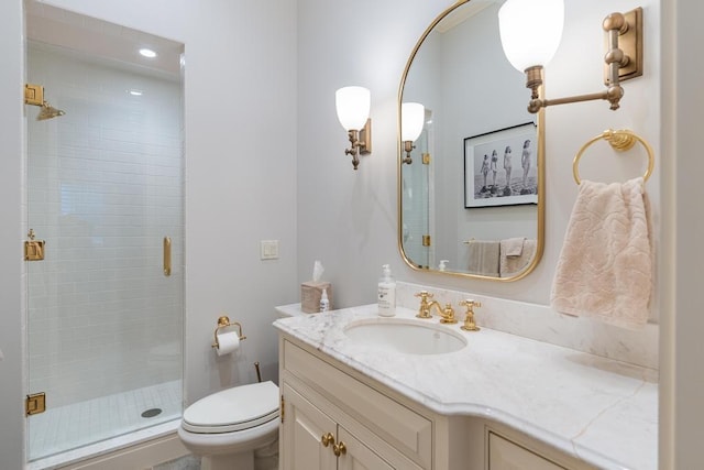 bathroom featuring vanity, toilet, and a shower with shower door