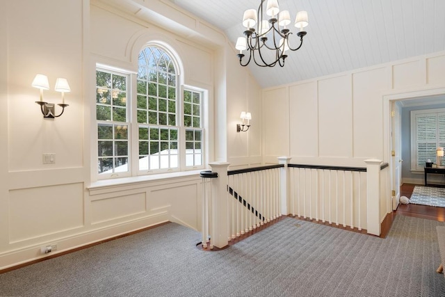 interior space featuring carpet, lofted ceiling, and a notable chandelier