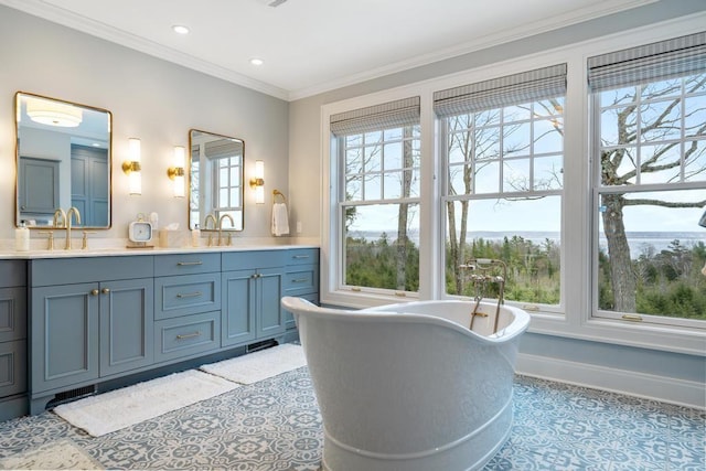 bathroom featuring tile patterned flooring, ornamental molding, vanity, and a bathing tub