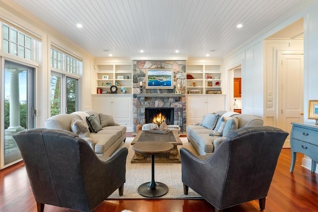 living room with wood ceiling, crown molding, wood-type flooring, built in features, and a fireplace