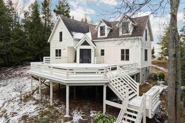 snow covered house featuring a wooden deck