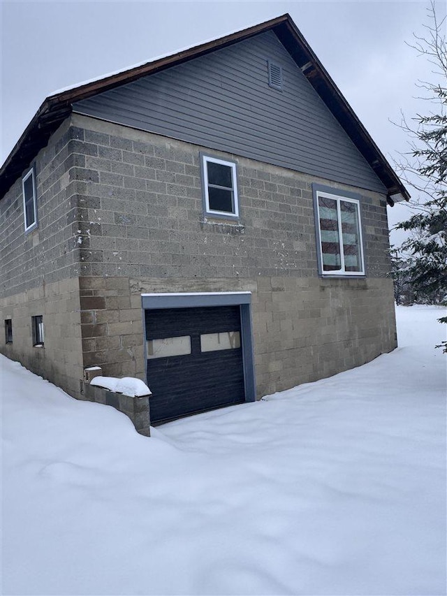 view of snow covered exterior featuring a garage