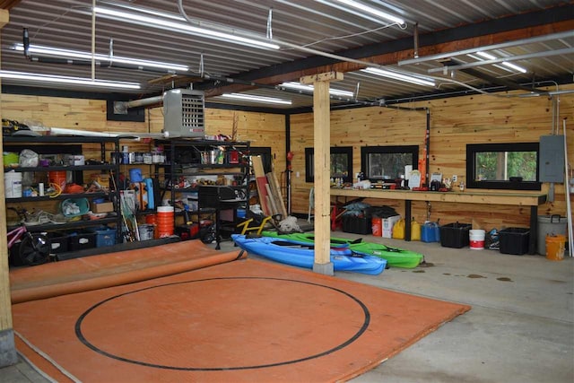 garage with electric panel, wooden walls, and a workshop area