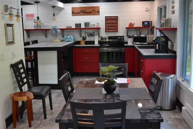 kitchen featuring appliances with stainless steel finishes, a baseboard heating unit, and hardwood / wood-style floors