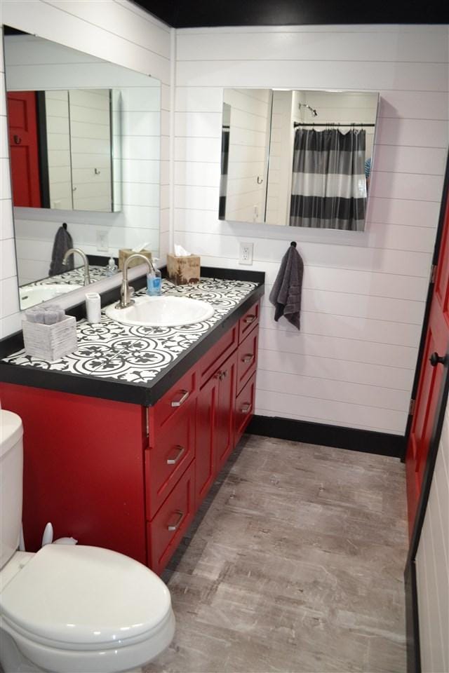 bathroom with hardwood / wood-style floors, vanity, and toilet